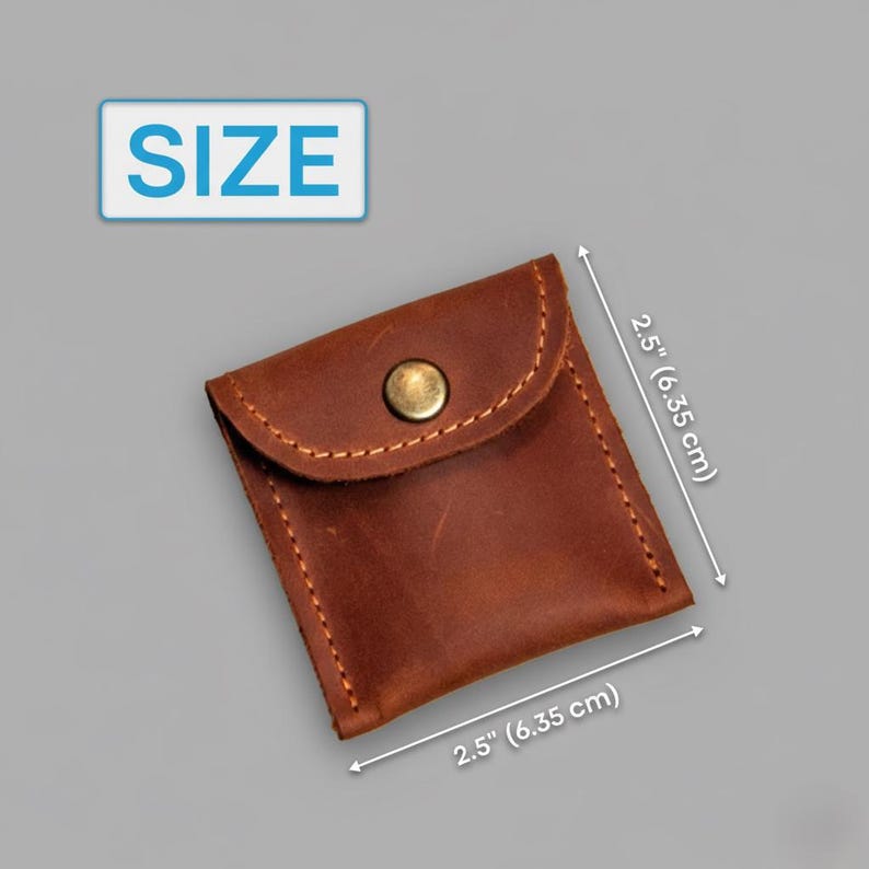 May include: A small, brown leather pouch with a flap closure and a brass button. The pouch is 2.5 inches (6.35 cm) square, with visible stitching. The word "SIZE" is in a blue rectangle in the upper left corner.