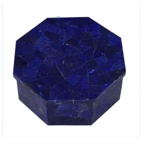 Puede incluir: Una caja octogonal con un diseño de mosaico. La caja es de color azul oscuro, con un patrón de formas irregulares. La caja probablemente está hecha de piedra o un material similar. La caja es un artículo decorativo.