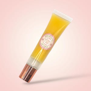 May include: A tube of yellow-tinted lip gloss. The tube has a white cap and a copper-coloured base. A pink label with a sheep illustration and the words "Shear Love Lip Care" is on the tube.