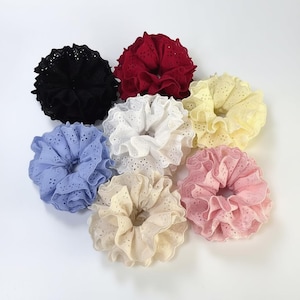 Puede incluir: Colección de siete coleteros en varios colores: negro, rojo, blanco, amarillo, azul, beige y rosa. Cada coletero está hecho de una tela con volantes y un delicado patrón de ojal.