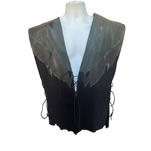 May include: A black leather vest with a lace-up front and a green and brown leather collar. The collar is made of several pieces of leather sewn together.