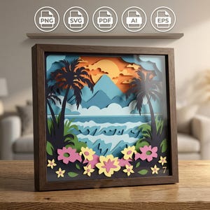 May include: A framed paper art piece showing a tropical beach scene with palm trees, mountains, and a sunset. The artwork uses layered paper cutouts in blue, orange, and green, with colourful flowers at the bottom. The frame is dark brown.