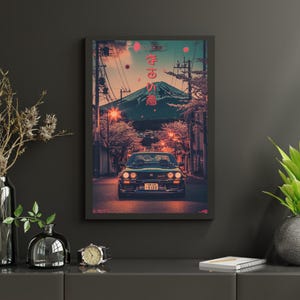 Könnte beinhalten: Gerahmter Kunstdruck mit einem Oldtimer auf einer Straße vor einem Berg. Das Bild hat einen Retro-Stil mit japanischem Text. Die Farbgebung umfasst Schwarz-, Orange- und Türkistöne und erzeugt ein Vintage-Feeling.