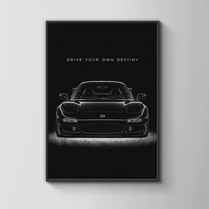Peut inclure: Une affiche murale en noir et blanc représentant une voiture de sport Mazda RX-7 noire vue de face, centrée sur un fond sombre. Le texte DRIVE YOUR OWN DESTINY est imprimé dans une police sans empattement blanche au-dessus du véhicule.