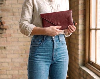 Bolso de mano tipo sobre rojo burdeos hecho a mano con cuero reciclado.