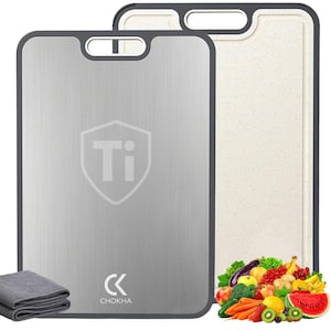 May include: Two rectangular cutting boards. One is stainless steel with a shield logo and the letters "Ti". The other is a beige speckled color. Both have a dark gray border and handle. A gray folded cloth and a pile of fresh fruit and vegetables are also in the image.