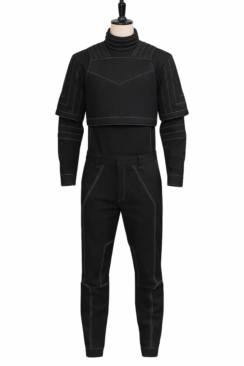 May include: A black outfit consisting of a turtleneck top, a cropped top with shoulder accents, and matching pants. The outfit features white stitching details. The clothing is displayed on a mannequin.