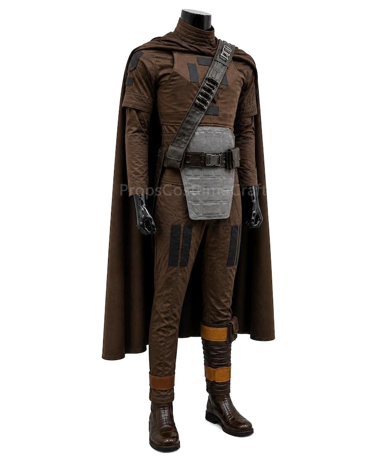 May include: A brown costume with a cape, high collar and chest plate. The outfit includes a belt, shoulder strap, and boots. The costume has black accents and is displayed on a mannequin.
