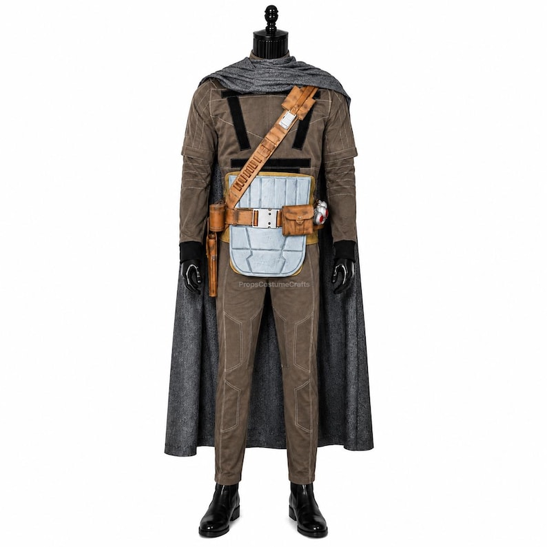 May include: A brown long-sleeved jumpsuit with a textured grey cape, a tan utility belt featuring a light blue rectangular plate, a brown holster, and a small pouch. The outfit includes black gloves and black boots, creating a complete ensemble.