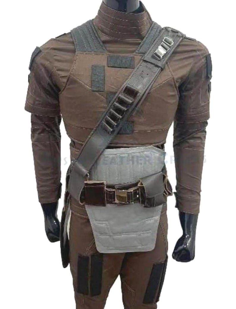 May include: Brown tactical vest and trousers set. The vest has a padded chest and shoulder straps with multiple pouches and a utility belt. The outfit is designed with a high collar and long sleeves. The overall design is a military-inspired style.