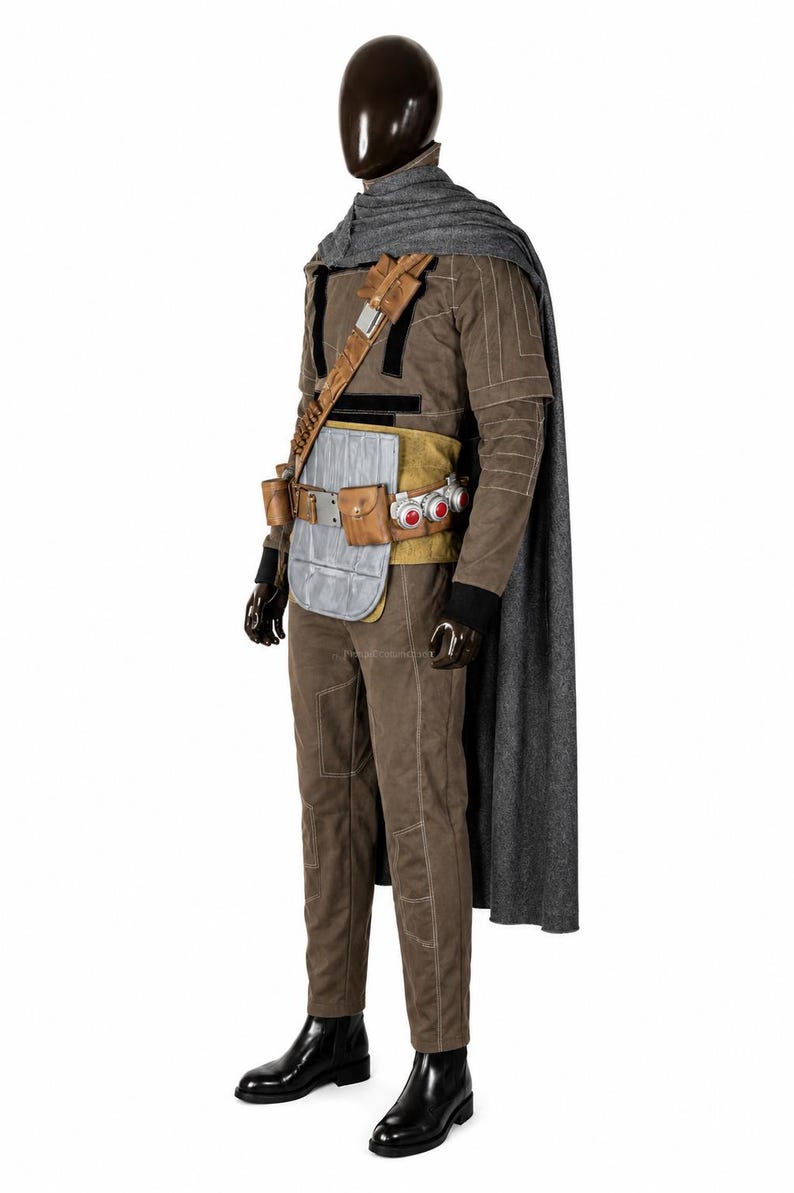 May include: A brown long-sleeved jumpsuit with white stitching, a grey cape, and a tan utility belt featuring silver plates, brown pouches, and three circular red accents. The outfit includes black gloves and black boots on a dark mannequin.