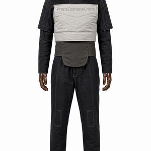 May include: A black long-sleeved shirt and matching trousers set featuring white contrast stitching. A light gray quilted chest panel with the text PropsCostumeCrafts is layered over the shirt, accompanied by a dark gray waist belt component.