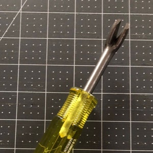 Puede incluir: Una herramienta amarilla y plateada con un extremo bifurcado. La herramienta está etiquetada como "C.S. OSBORNE HARRISON".