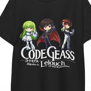 May include: Black t-shirt featuring three anime characters and the text "Code Geass Lelouch of the Rebellion" in white. The characters have green, brown, and red hair, and are wearing white and black outfits. The shirt is hanging on a wooden hanger.