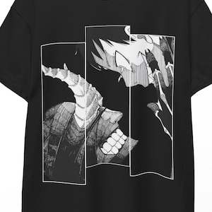 May include: Black t-shirt with a manga-style illustration in white and grey. The design is split into three rectangular panels, displaying a detailed illustration of a character's face and features.