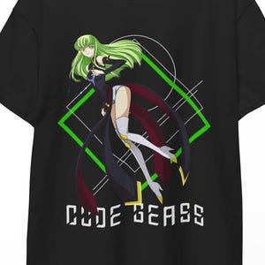 May include: Black t-shirt featuring a graphic of an anime character with green hair and a black and red outfit. The design includes a green geometric shape and the text "CODE GEASS" in white.