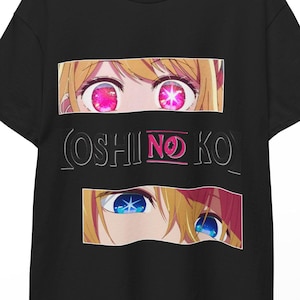 May include: Black t-shirt featuring anime-style eyes with pink and blue irises, and the text "OSHI NO KO" in white. The shirt is hanging on a wooden hanger.