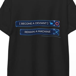Könnte beinhalten: Schwarzes T-Shirt mit dem Text "[BECOME A DEVIANT]" über "REMAIN A MACHINE" in blauer, futuristisch anmutender Schrift. Das Design beinhaltet einen blauen Kreis und ein "X"-Symbol. Das T-Shirt hängt an einem Holzkleiderbügel.