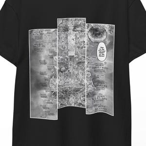 以下が含まれることがあります： 黒いTシャツ。白黒の漫画パネルのデザイン。グラフィックは非常に詳細で、複雑なイラストとテキストが特徴です。Tシャツは木製のハンガーに掛けられています。