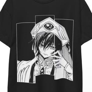 May include: Black t-shirt featuring a black and white anime illustration. The graphic depicts a character with long hair and a detailed headpiece. The design is framed within a white rectangular border.