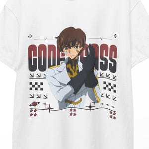 May include: White t-shirt featuring a graphic of an anime character in a white jacket and black gloves. The text "CODE GEASS" is printed in red and black above the character. The shirt is hanging on a wooden hanger.