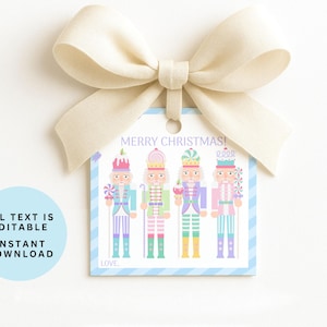 May include: A Christmas gift tag with four colorful nutcracker illustrations. The tag has a light blue border with vertical stripes and the words "MERRY CHRISTMAS!" at the top. A cream-colored bow is attached to the top.