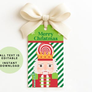 May include: A Christmas gift tag with a green background and the words "Merry Christmas". The tag features a nutcracker illustration with a crown and candy cane. A cream-colored bow is attached at the top. The text "ALL TEXT IS EDITABLE INSTANT DOWNLOAD" is also present.