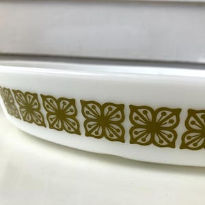 May include: White oval baking dish with a green floral pattern around the rim.