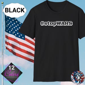 May include: Black t-shirt with the white text "#stopWARS". An American flag waves in the background. The shirt is displayed with a "12 Colors" graphic and a "BLACK" label.
