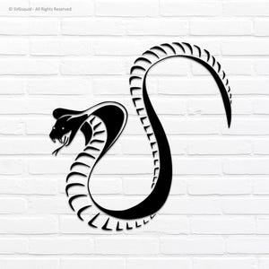 May include: A black cobra snake design against a white brick wall. The snake is stylized with a curved body and a raised hood, with a detailed head and open mouth. The design is a silhouette, with the snake's scales and features clearly defined.
