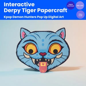 May include: A blue papercraft tiger head with large yellow eyes, sharp teeth, and a pink tongue that says "Pull." The design includes the text "Interactive Derpy Tiger Papercraft" and "Kpop Demon Hunters Pop Up Digital Art."