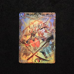 K&ouml;nnte beinhalten: Sammelkarte mit einer gold-orangenen Illustration einer Kriegerin mit einem Schwert. Die Karte hat japanischen Text und die Zahl "6000" unten. Der Hintergrund ist schwarz.