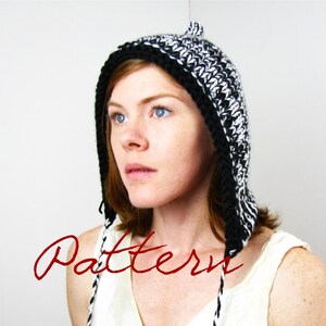 May include: A black and white crocheted hooded hat with long ties. The hat has a pointed top and a textured pattern.