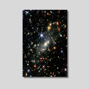 May include: A rectangular print showcasing a vibrant image of a galaxy filled with numerous stars and celestial bodies. The artwork features a dark background with bright, sparkling points of light, creating a cosmic scene.