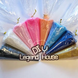 May include: A collection of colorful powders in clear plastic bags, tied with gold twist ties. The powders are in shades of pink, orange, blue, and gold. The text "DIY Legend House" is visible.