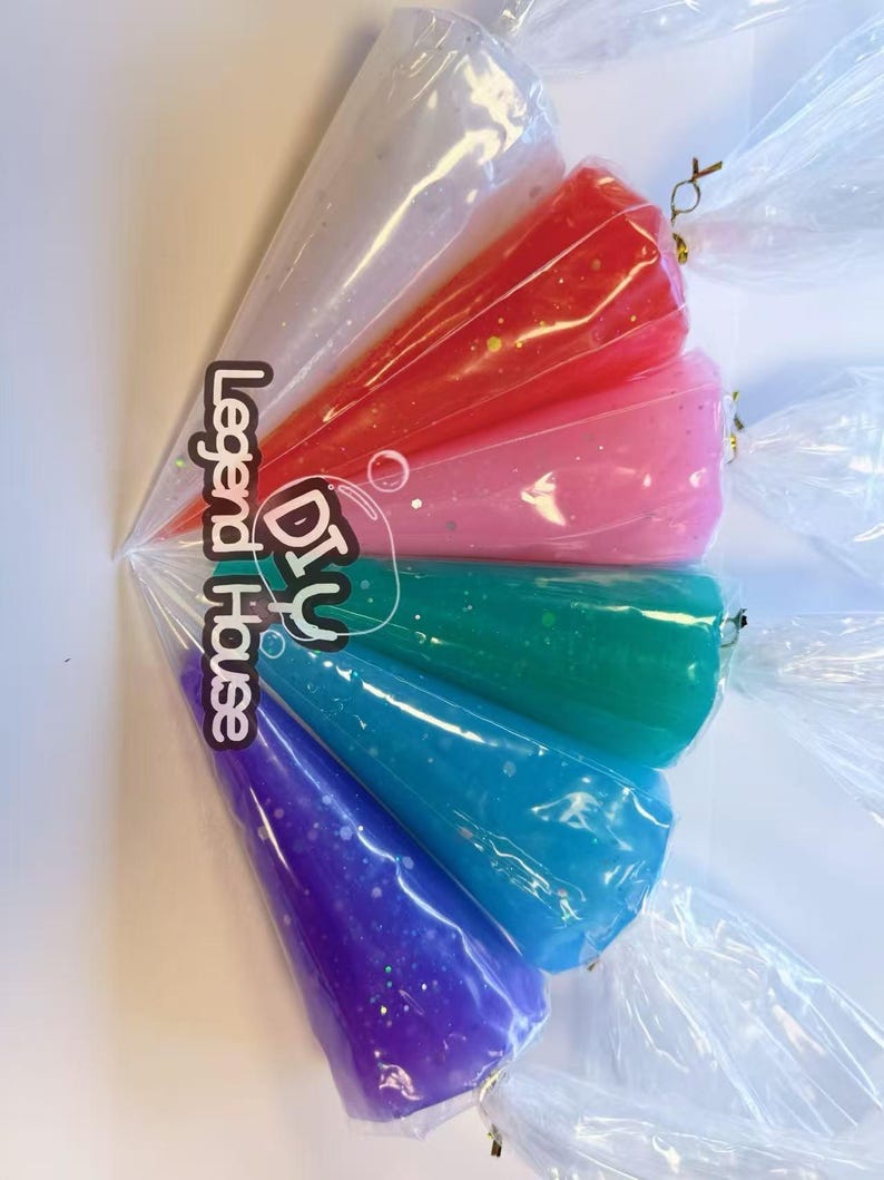 May include: A collection of colorful, cone-shaped DIY slime kits in clear plastic bags. The slimes are in shades of white, red, pink, green, blue, and purple, with glitter accents. The bags are tied with gold twist ties. The text "DIY House Legend" is visible.