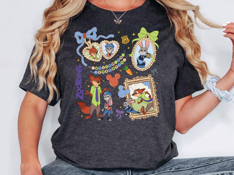 Op de afbeelding: Donkergrijs T-shirt met kleurrijke illustraties van personages uit de animatiefilm Zootopia. Het ontwerp bevat ingelijste portretten, karakterkoppels en het logo van de film. Het shirt heeft een ronde hals en korte mouwen.