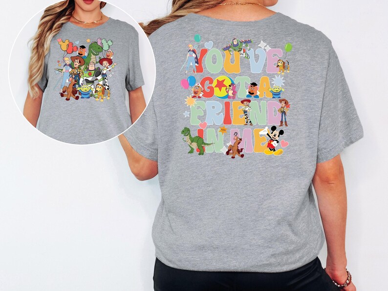 May include: A grey t-shirt with cartoon characters on the front and back. The front has a group of characters, and the back says "You've Got a Friend in Me" with more characters in a colourful design.