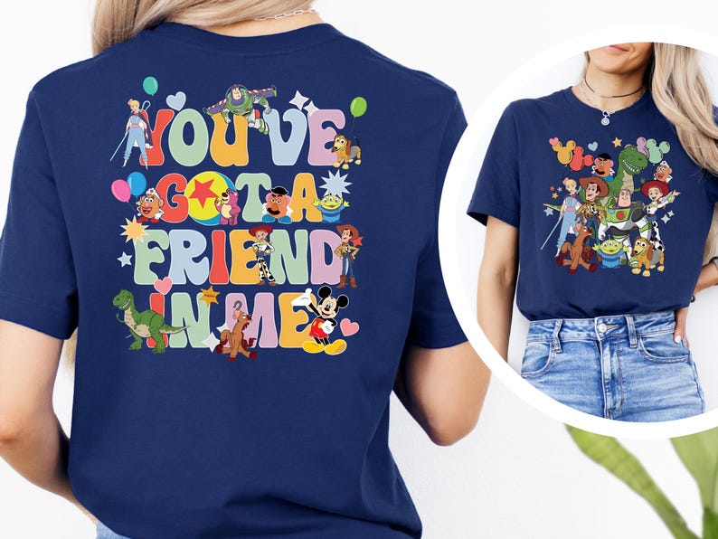 May include: A navy blue t-shirt with a vibrant graphic. The design features the phrase "You've Got A Friend In Me" and cartoon characters such as Buzz Lightyear and Mickey Mouse. The shirt is a classic crew neck.