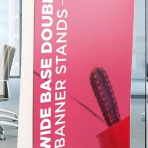 Może przedstawiać: Wysoki stojak na baner z białą ramą i żywym r&oacute;żowym wyświetlaczem. Na banerze znajduje się biały tekst: &bdquo;DELUXE WIDE BASE DOUBLE SCREEN ROLLUP BANNER STANDS&rdquo;. Widoczny jest czerwony garnek z kaktusem.
