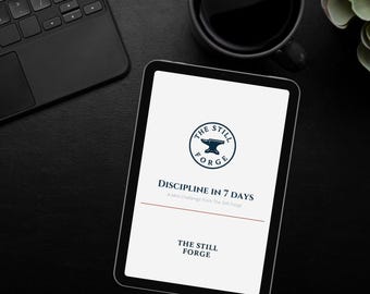 Może przedstawiać: Czarny tablet wyświetla tekst "DISCIPLINE IN 7 DAYS" i "THE STILL FORGE" z logo. Czarna klawiatura i filiżanka kawy są widoczne na czarnej powierzchni. Ekran tabletu jest biały z niebieskim i czerwonym tekstem.