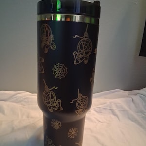 Puede incluir: Un termo negro con borde y tapa dorados. El termo est&aacute; decorado con gr&aacute;ficos dorados de Spider-Man y telara&ntilde;as. Dise&ntilde;ado para mantener las bebidas calientes o fr&iacute;as.
