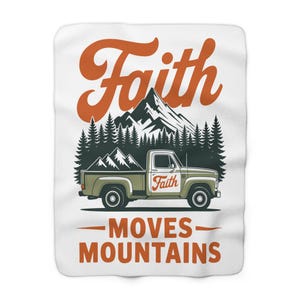May include: A white blanket featuring a graphic of a green pickup truck with a mountain backdrop. The words "Faith" and "MOVES MOUNTAINS" are displayed in orange. The blanket has a soft, plush texture, ideal for snuggling.