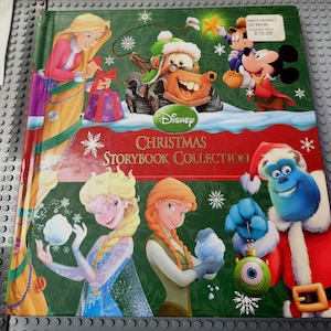 May include: A Disney Christmas Storybook Collection book with a green cover featuring Disney characters. The cover includes Rapunzel, Mater, Mickey Mouse, Elsa, Anna, and Sulley. The title is in red and white.