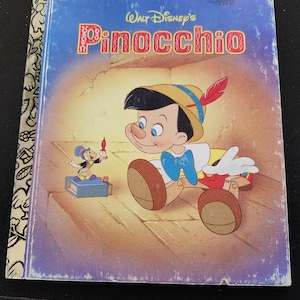 May include: A vintage Little Golden Book titled "Pinocchio" by Walt Disney. The cover features an illustration of Pinocchio and Jiminy Cricket. The book has a blue and gold cover with a worn appearance.