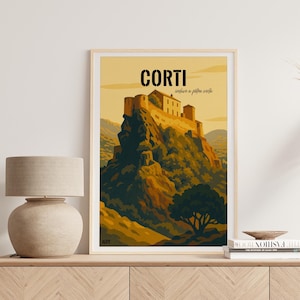 以下が含まれることがあります： 「CORTI」の文字が太字で書かれた、コルティのヴィンテージ旅行ポスターをあしらった額入りのアートプリント。ポスターは山の頂上にある城を描いており、黄色、緑、茶色の暖色系の色使いです。プリントは明るい木製のキャビネットに飾られています。