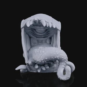 May include: A detailed, gray sculpture of a creature's open mouth, teeth, and tongue. The tongue curls out of the mouth, and the teeth are sharp and pointed. The sculpture is set against a black background.