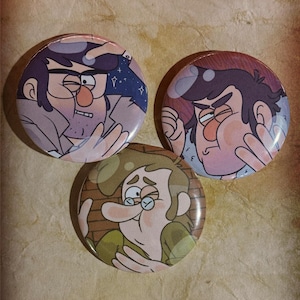 May include: Three round pinback buttons featuring cartoon characters. Two buttons depict a man with dark hair and a surprised expression. The third button shows a man with glasses and a concerned look. The buttons have a glossy finish.
