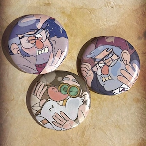May include: Three round pinback buttons featuring cartoon characters with glasses and expressive faces. The buttons have a glossy finish and are set against a textured, tan background. The characters are depicted in various colors, including blue, gray, and pink.