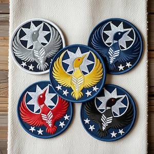 Könnte beinhalten: Fünf runde, gestickte Aufnäher mit einem Vogeldesign. Die Aufnäher zeigen einen Vogel mit ausgebreiteten Flügeln, einen Stern und kleine Sterne am Rand. Die Farben sind Grau, Gelb, Rot, Blau und Schwarz, alles auf marineblauem Hintergrund.